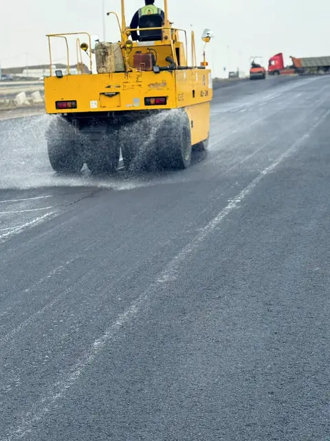 Roller with water spray on hot mix